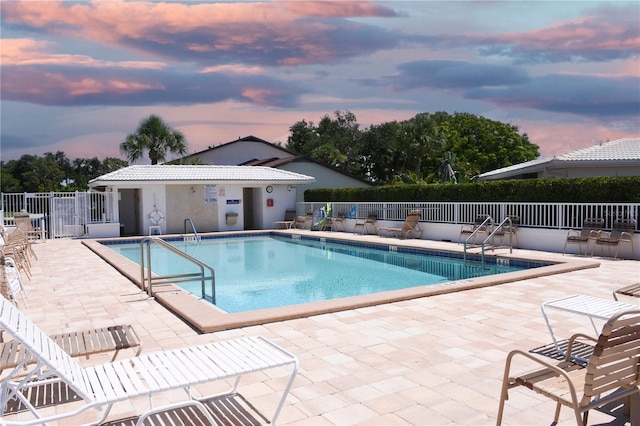 pool at dusk with a patio