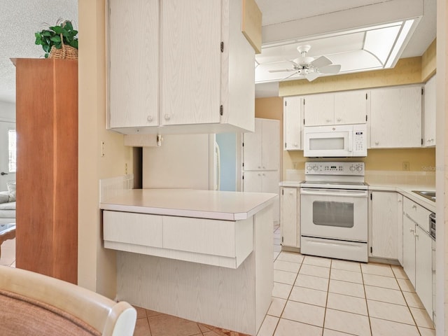 kitchen featuring white appliances, ceiling fan, white cabinetry, light tile patterned flooring, and kitchen peninsula