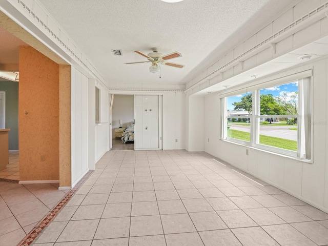 spare room featuring light tile patterned flooring, a textured ceiling, and ceiling fan