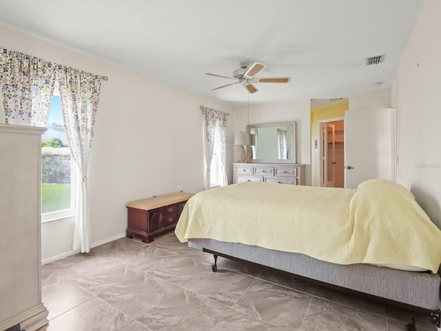 bedroom with ceiling fan and a walk in closet