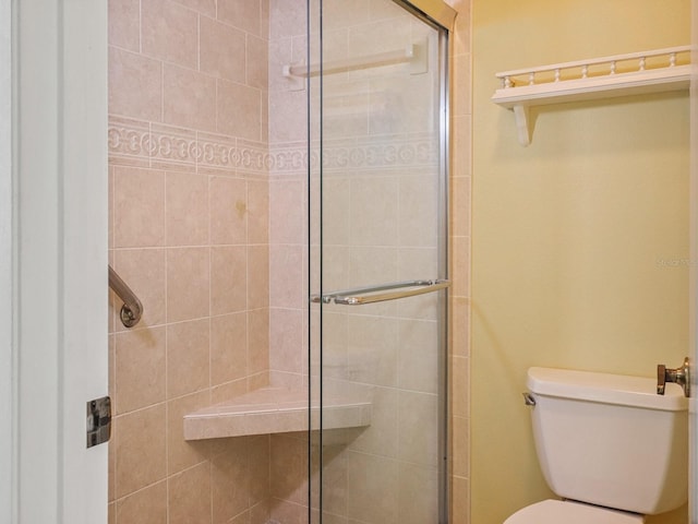 bathroom featuring an enclosed shower and toilet