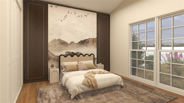 bedroom with light wood-type flooring and vaulted ceiling