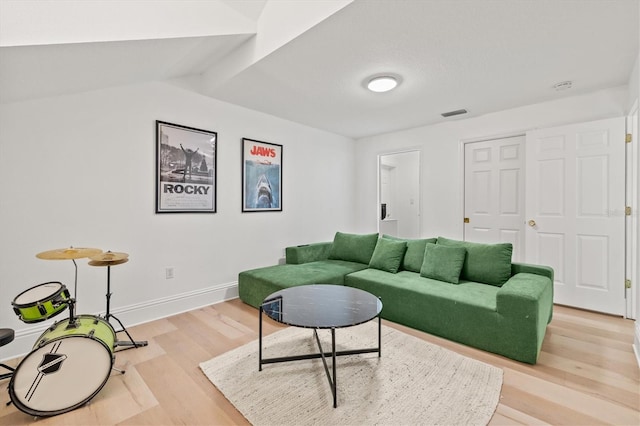 living room with vaulted ceiling and light wood-type flooring