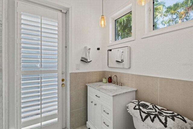 bathroom featuring vanity and tile walls