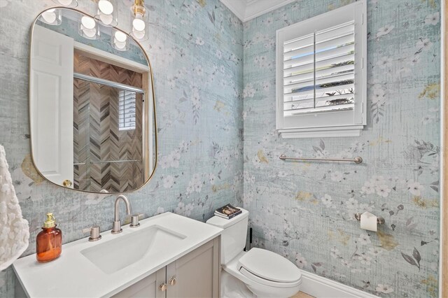 bathroom with vanity, toilet, and ornamental molding