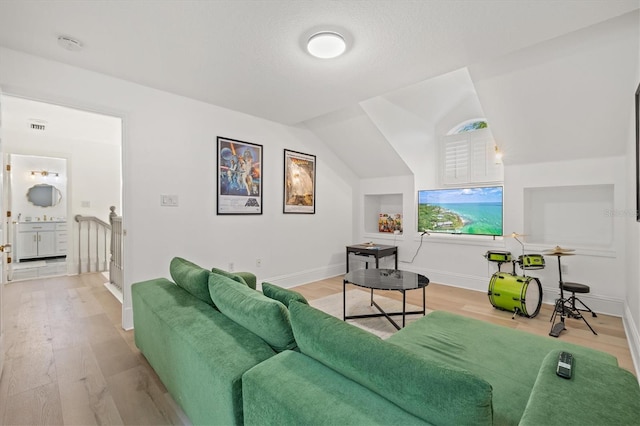 living room featuring lofted ceiling and light wood-type flooring