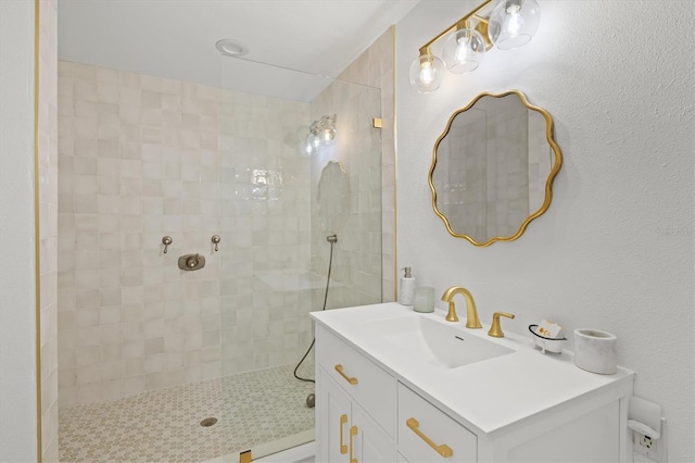 bathroom with vanity and tiled shower