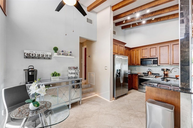 kitchen featuring appliances with stainless steel finishes, dark stone countertops, decorative backsplash, sink, and beam ceiling