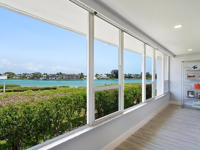 unfurnished sunroom featuring a water view