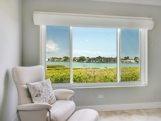 sitting room featuring a water view and a wealth of natural light