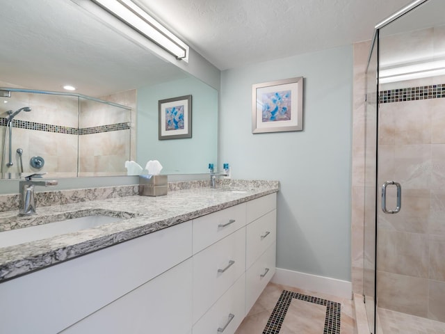 bathroom featuring tile patterned floors, vanity, a textured ceiling, and walk in shower