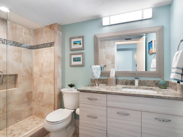 bathroom featuring vanity, toilet, and an enclosed shower