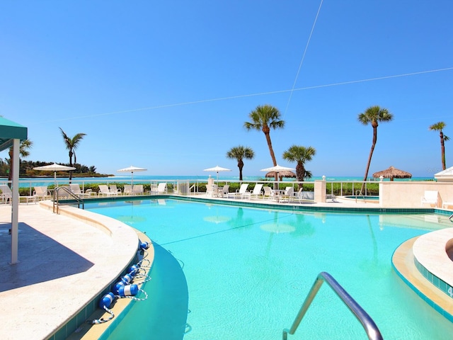 view of pool with a water view and a patio area