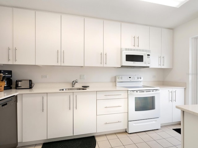 kitchen with light tile patterned floors, white cabinets, white appliances, and sink