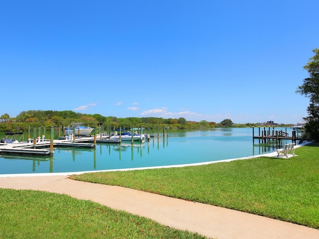 view of dock with a yard and a water view