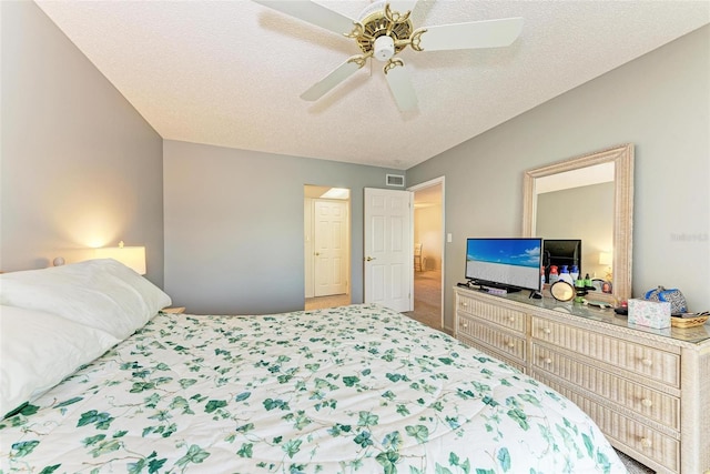 carpeted bedroom featuring ceiling fan and a textured ceiling