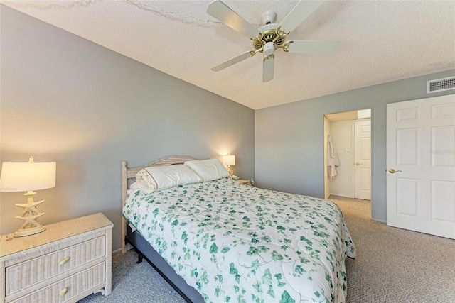 carpeted bedroom featuring ceiling fan and a textured ceiling