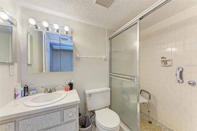 bathroom featuring a shower with door, large vanity, toilet, and a textured ceiling