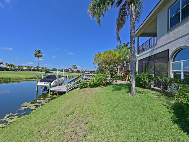 view of dock featuring a balcony, a yard, and a water view