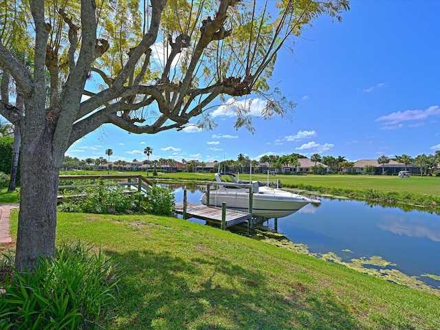 view of dock featuring a water view and a yard