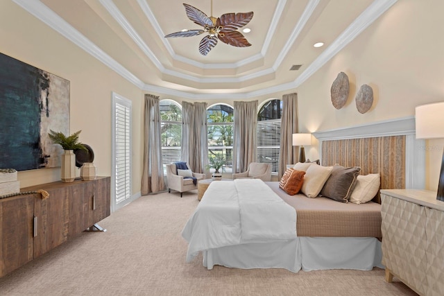 carpeted bedroom featuring ceiling fan, crown molding, and a tray ceiling