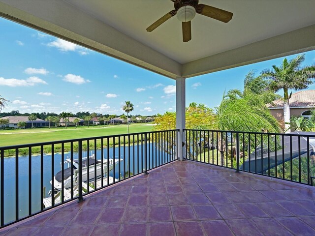 balcony with ceiling fan and a water view