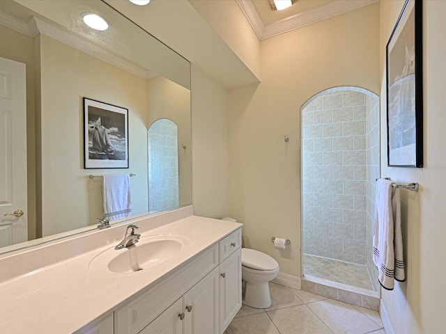 bathroom featuring tile patterned floors, toilet, a tile shower, vanity, and crown molding