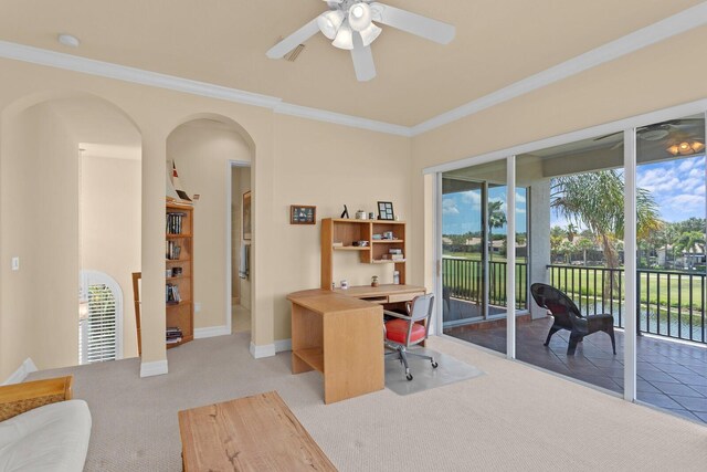 carpeted office featuring ceiling fan, a water view, and ornamental molding