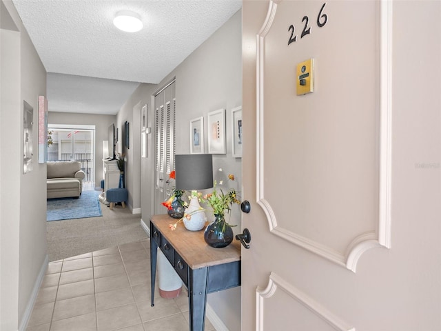 hall featuring a textured ceiling and tile flooring