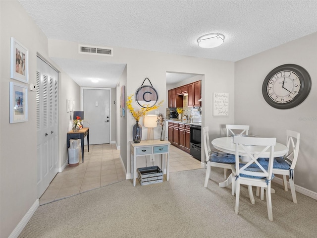 carpeted dining room featuring a textured ceiling and sink