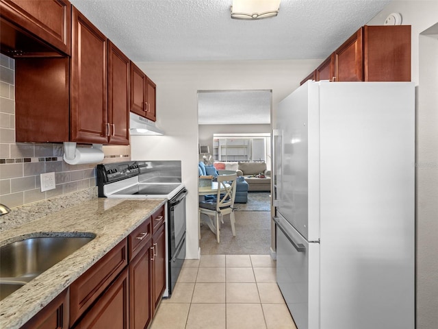 kitchen featuring exhaust hood, light stone counters, range with electric cooktop, backsplash, and white refrigerator