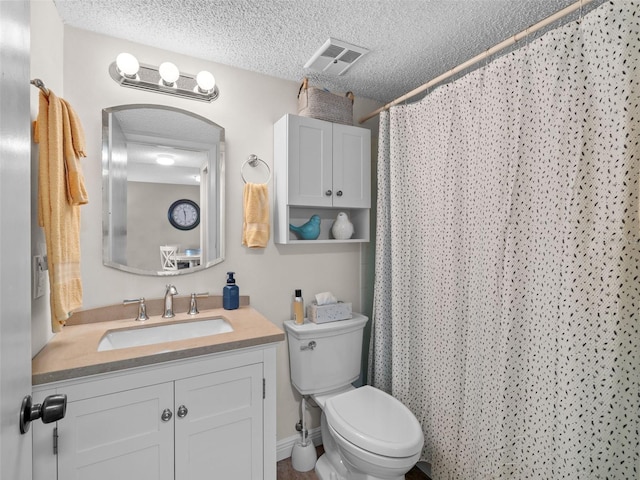 bathroom featuring a textured ceiling, large vanity, and toilet