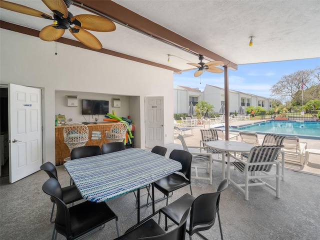 view of patio / terrace with ceiling fan and a community pool