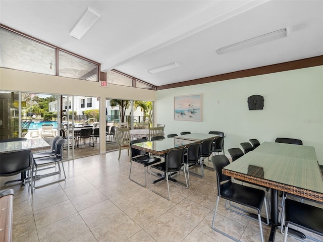 dining area featuring lofted ceiling with beams and light tile floors