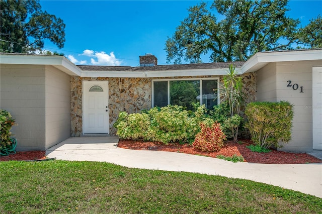 doorway to property featuring a lawn