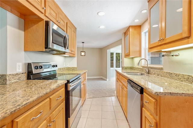 kitchen with light stone countertops, decorative light fixtures, stainless steel appliances, light tile flooring, and sink