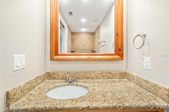 bathroom featuring vanity and a tile shower