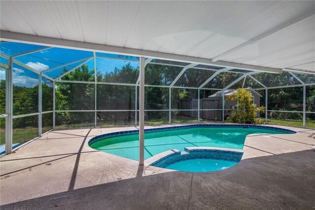 view of pool with a lanai, an in ground hot tub, and a patio area