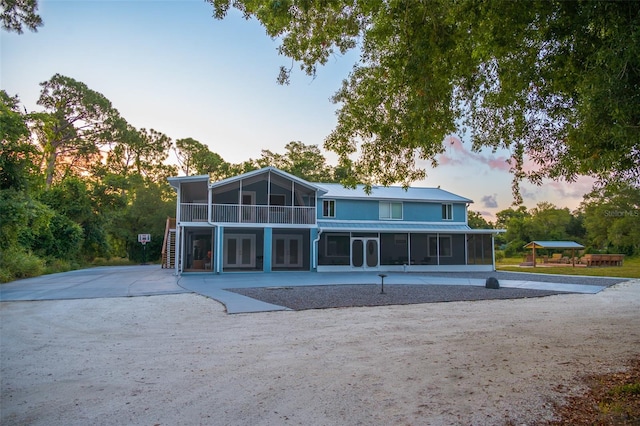 back house at dusk with a sunroom