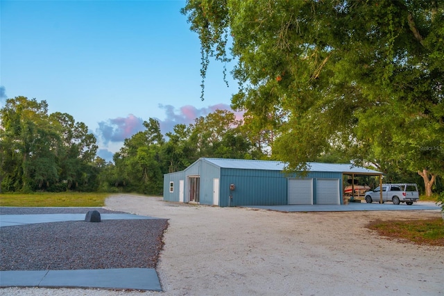 view of property exterior with a garage, a carport, and an outdoor structure