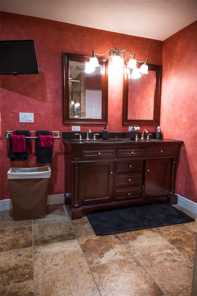 bathroom featuring double vanity, tile flooring, and a textured ceiling