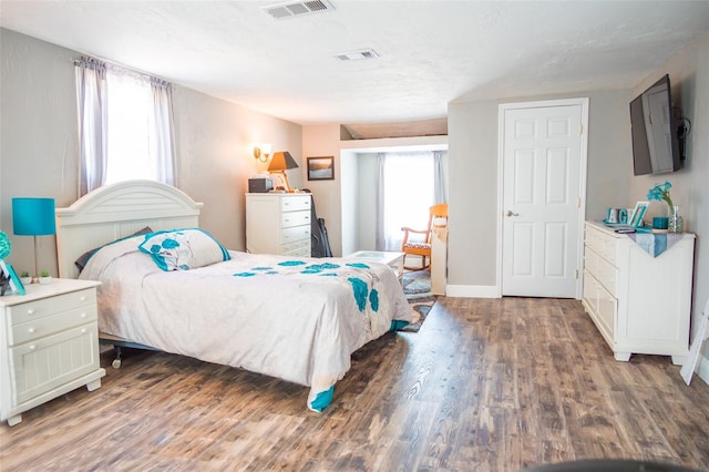 bedroom with hardwood / wood-style floors and multiple windows