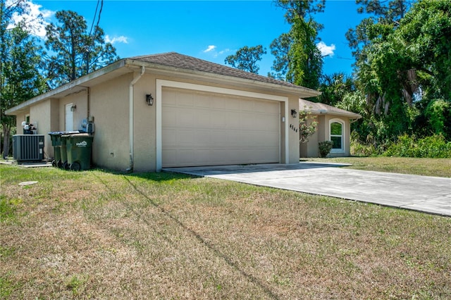 view of front of home featuring a garage, central AC unit, and a front yard