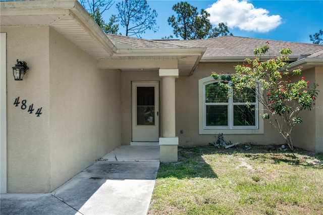 doorway to property featuring a lawn