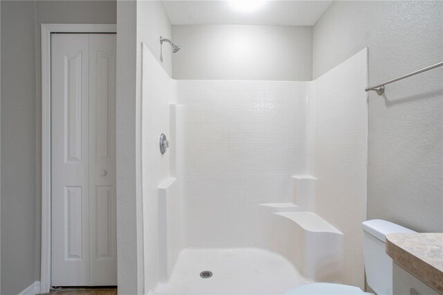 bathroom featuring vanity, toilet, and walk in shower