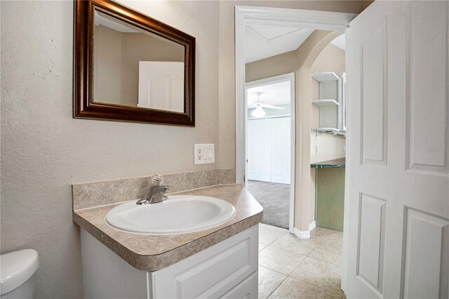 bathroom featuring tile patterned floors, vanity, ceiling fan, and toilet