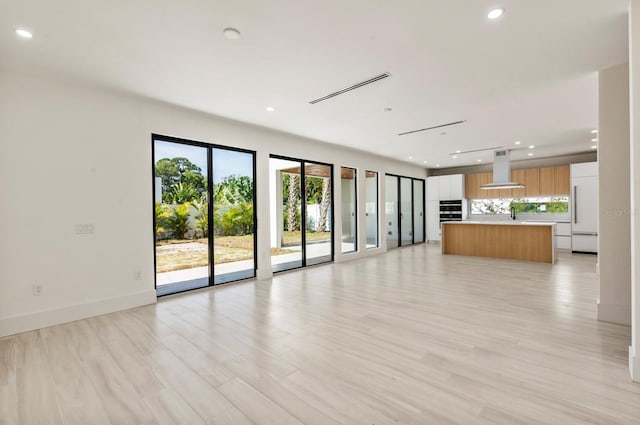 unfurnished living room featuring sink and light wood-type flooring