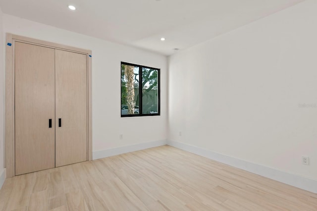 unfurnished bedroom with light hardwood / wood-style flooring and a closet