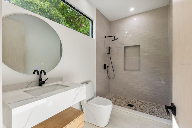 bathroom featuring tiled shower, tile flooring, vanity, and toilet