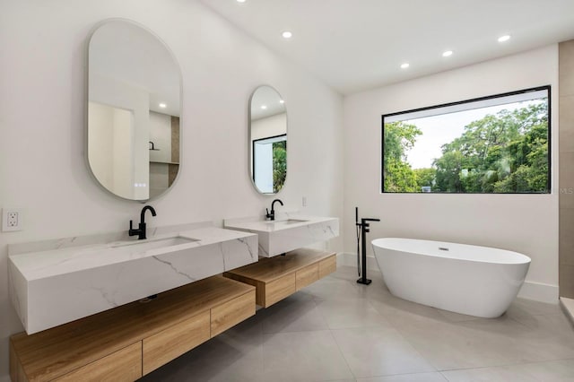 bathroom with tile floors, a bath, and double sink vanity